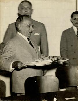 Getúlio Vargas segurando uma bandeja.